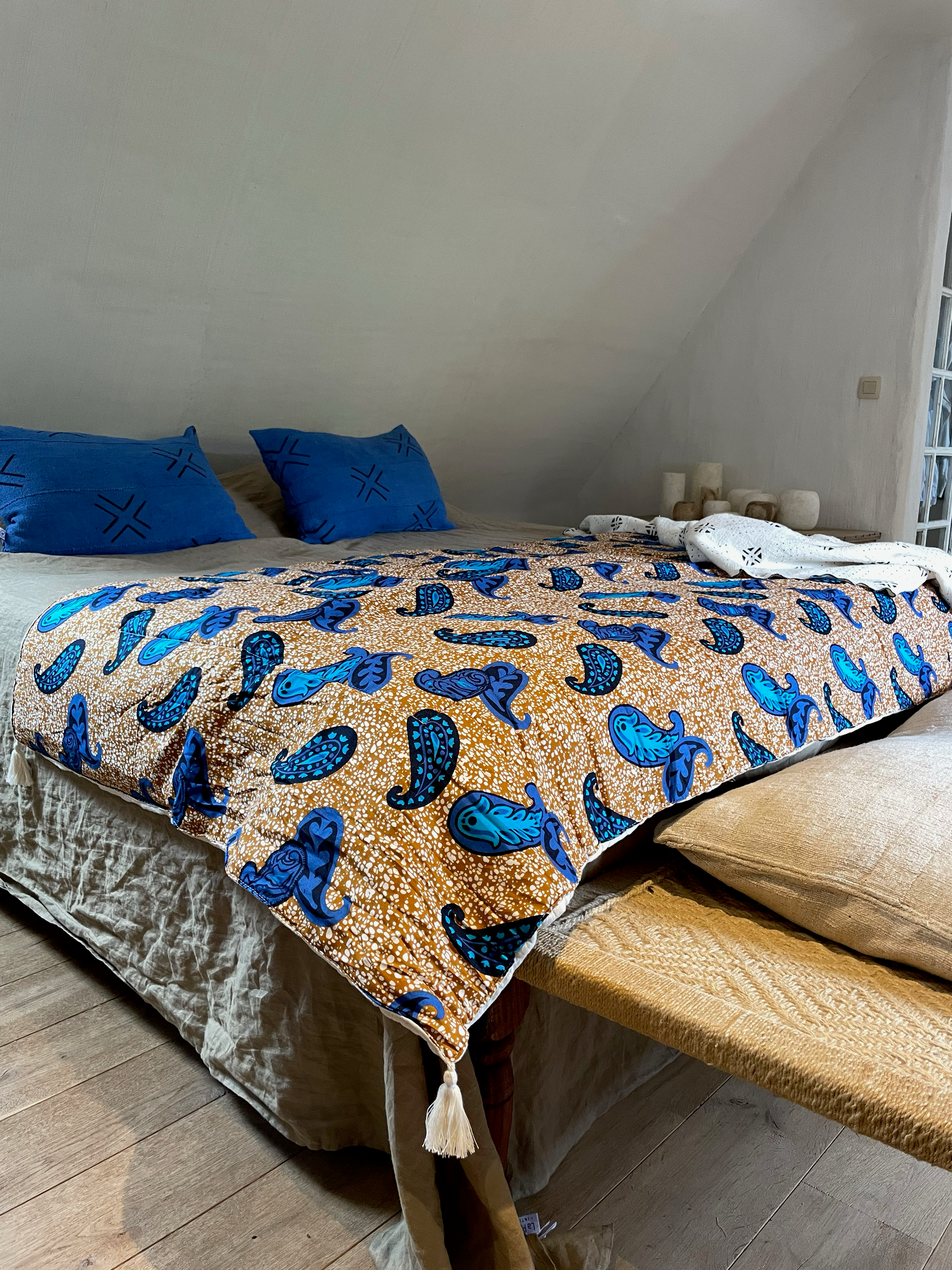 Esprit chic et bohème dans la chambre avec les housses de coussin MALI en bogolan bleu cobalt. Combiné au couvre-pieds FUNTENI par Studio Matongé et au plaid en bogolan blanc pur coton bio Lengo. Nos pièces sont faites main, confectionnées artisanalement. 