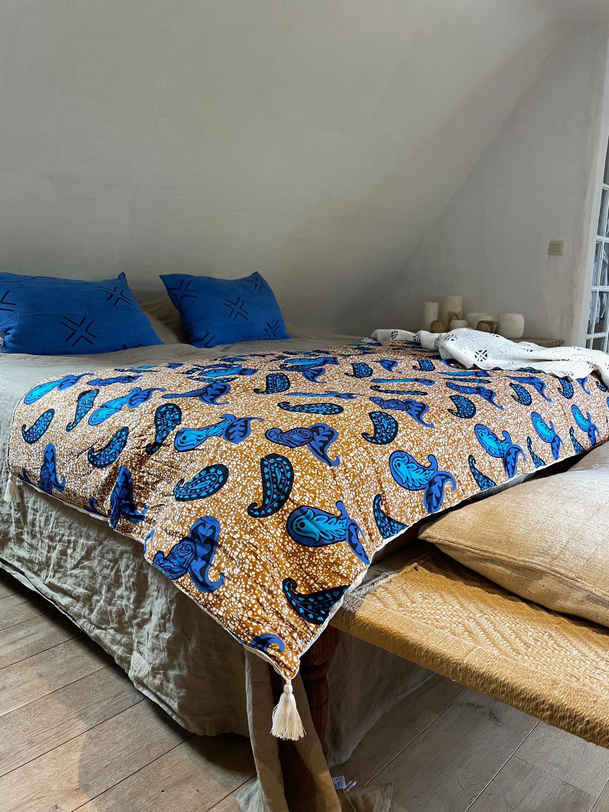 Esprit chic et bohème dans la chambre avec les housses de coussin MALI en bogolan bleu cobalt. Combiné au couvre-pieds FUNTENI par Studio Matongé et au plaid en bogolan blanc pur coton bio Lengo. Nos pièces sont faites main, confectionnées artisanalement. 