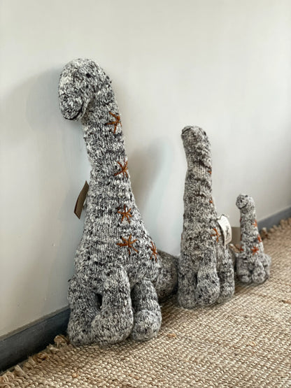 NESSIE, doudou brontosaure en laine mérinos. Fait main par les femmes artisans de la coopérative kenyane Kenana Knitters. Cette sympathique peluche dinosaure est disponible en 3 tailles. 