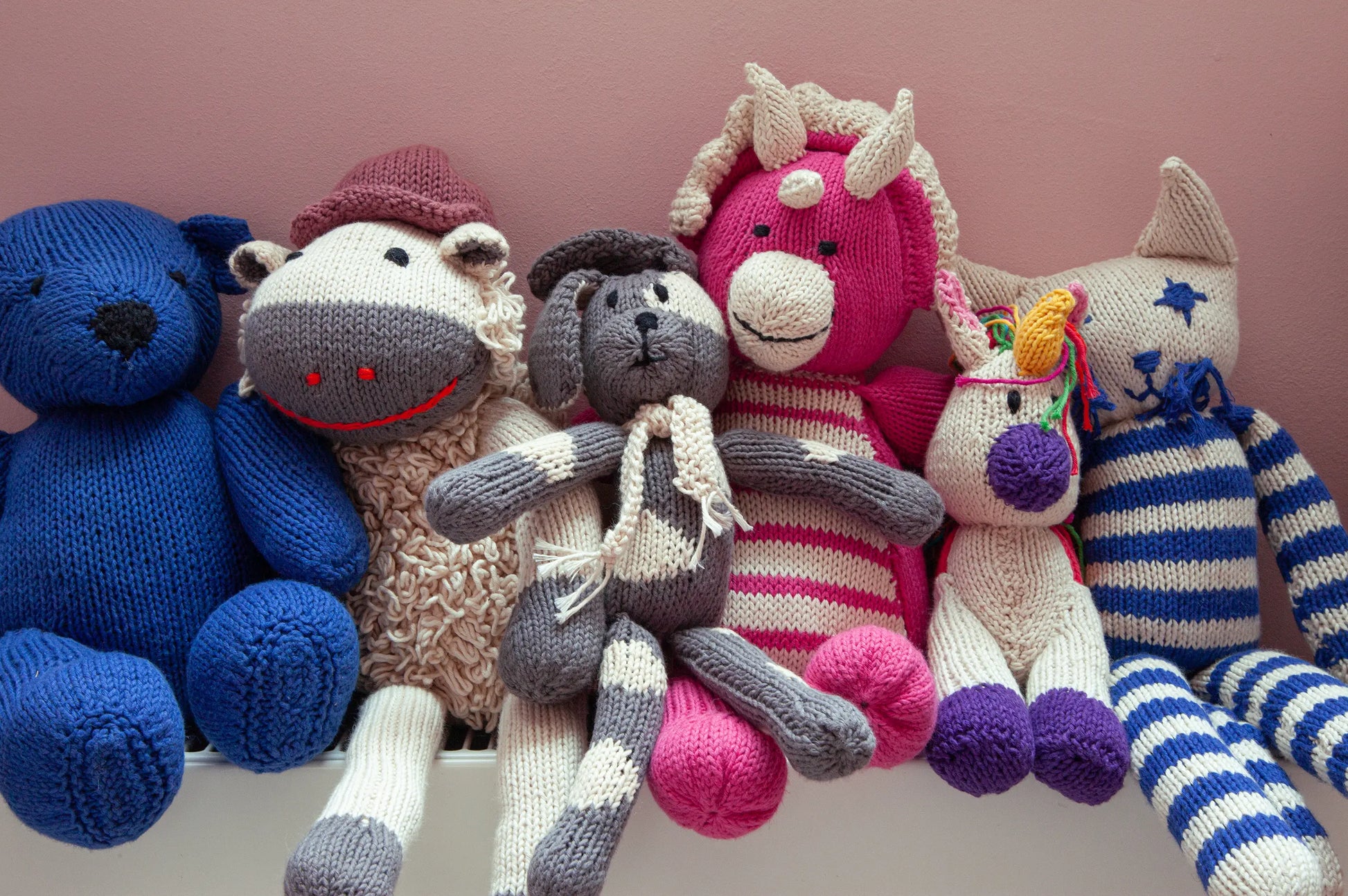 Collection de doudous en coton bio certifié GOTS. Tous nos doudous l'ours bleu LEON, le mouton HECTOR en taille M, le chien MAX, le tricératops en taille M, LILI la licorne, MALO le chat, sont tricotés main. 