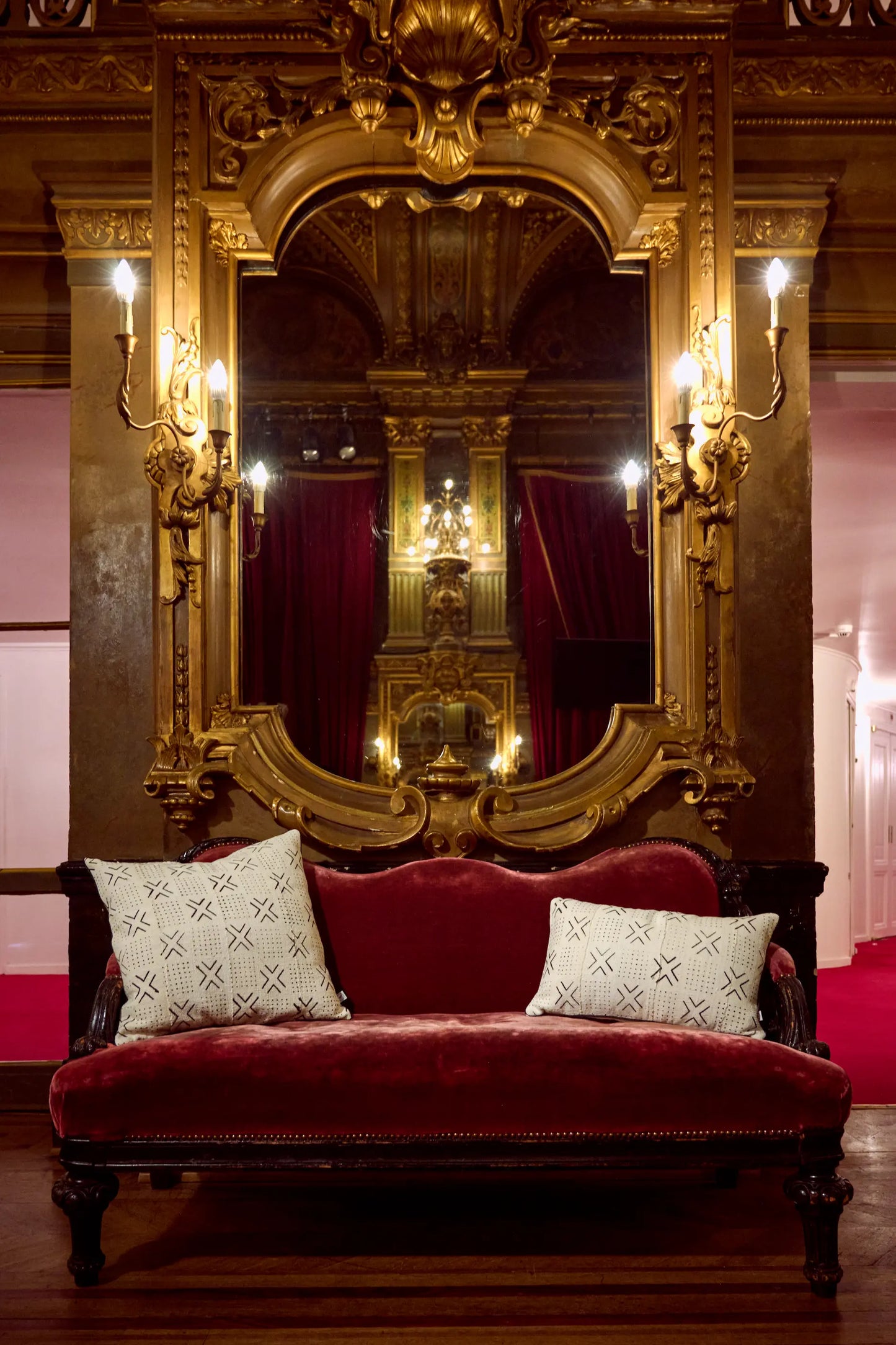 Dans les magnifiques décors du grand foyer de l'Opéra de la Monnaie de Bruxelles, housses de coussins MSALABA-PAN - Studio Matongé, en format carré 50 x 50 cm et rectangulaire 30 x 50 cm. Versatiles, nos coussins bi-matières s'adaptent à vos envies : une face en Bogolan de coton bio ornée de motifs ethniques tracés à la main ou au pochoir et une face unie en épais lin blanc rehaussée d'un élégant passepoil noir. 