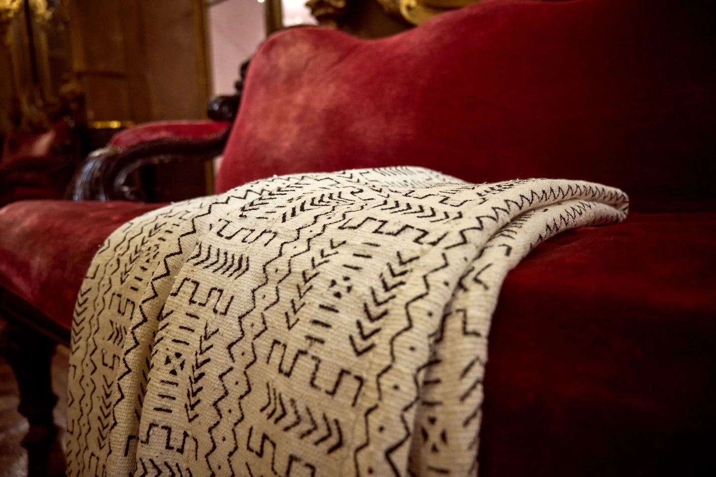 Dans les magnifiques décors de l'Opéra de la Monnaie de Bruxelles, plaid blanc en bogolan mudcloth pur coton - KIKABILA - Studio Matongé. Fait main au Mali dans la région de San, teintures naturelles. Finitions à la main en Belgique