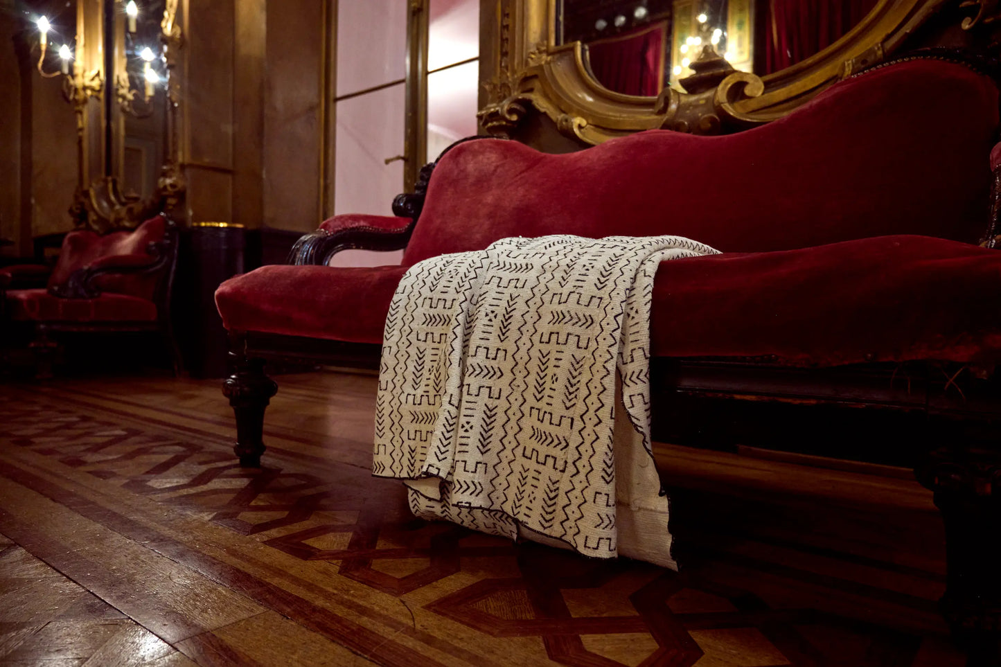 Dans les magnifiques décors de l'Opéra de la Monnaie de Bruxelles, plaid blanc en bogolan mudcloth pur coton - KIKABILA - Studio Matongé. Fait main au Mali dans la région de San, Teintures naturelles. Finitions à la main en Belgique