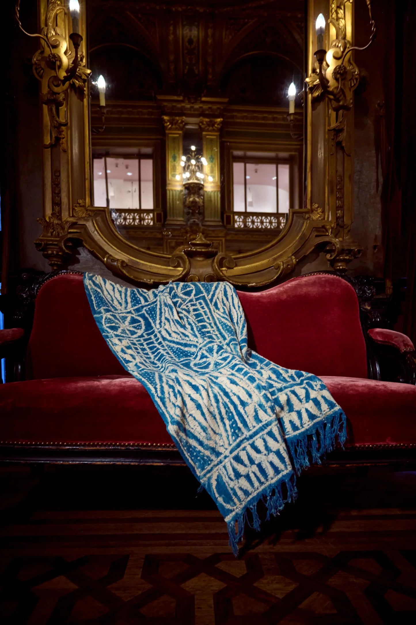 Sous les ors et le classicisme des décors du grand foyer de l'Opéra de la Monnaie à Bruxelles, notre non moins royal plaid NAMTCHEMA en ndop vintage. Tissé et teint à la main au Cameroun. Teinture végétale naturelle à l'indigo.