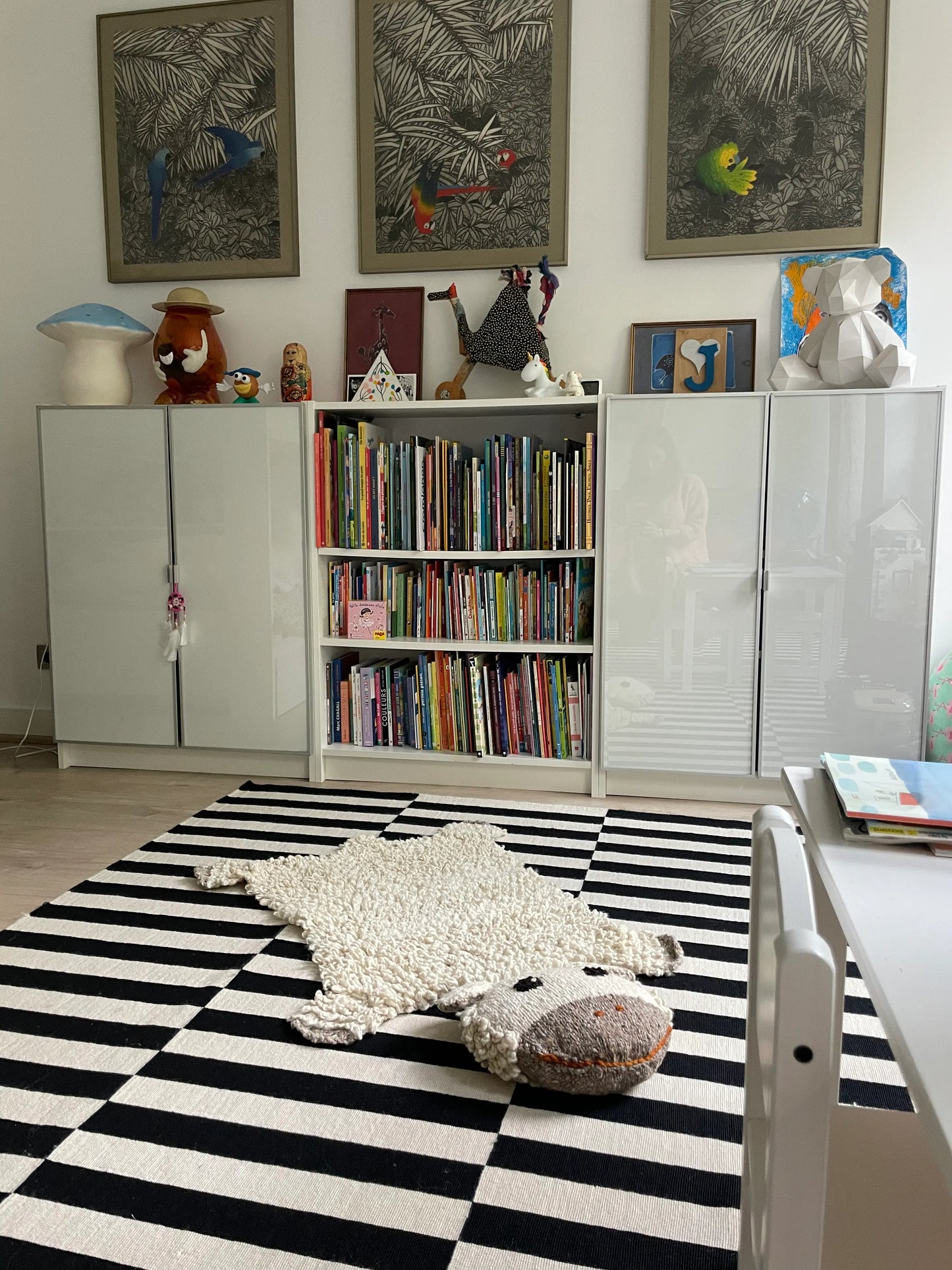 Dans une chambre d'enfant, tapis mouton SHEEPY en pure laine. Super amusants avec sa grosse tête rembourrée propice à la lecture ou à la rêverie de nos chers petits anges.