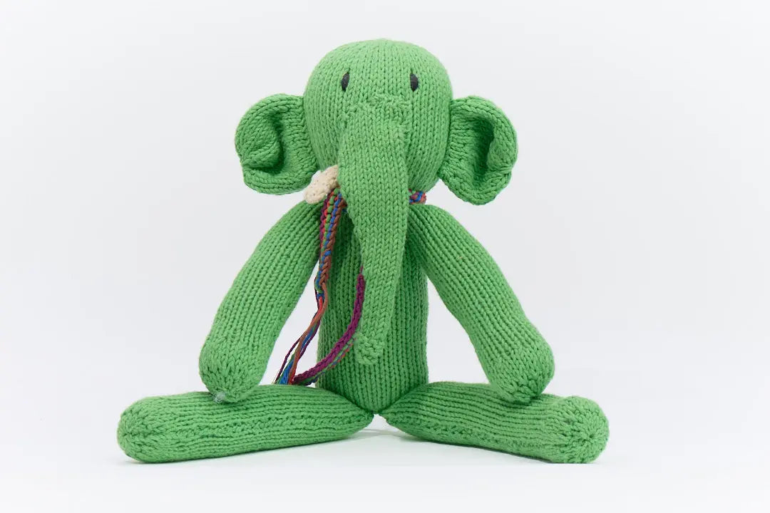 Doudou éléphant gris à longues pattes. Modèle MARGE, fait main par la coopérative Kenana Knitters. En coton bio tout doux certifié GOTS. Utilisable dès la naissance.
L'éléphant MARGE est présenté ici en vert taille M