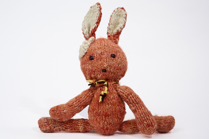 SIMONE, peluche lapin corail, taille S,  en laine bio faite main éco-responsable. Le doudou lapin SIMONE est disponible en 2 tailles et plusieurs couleurs chez Studio Matongé.