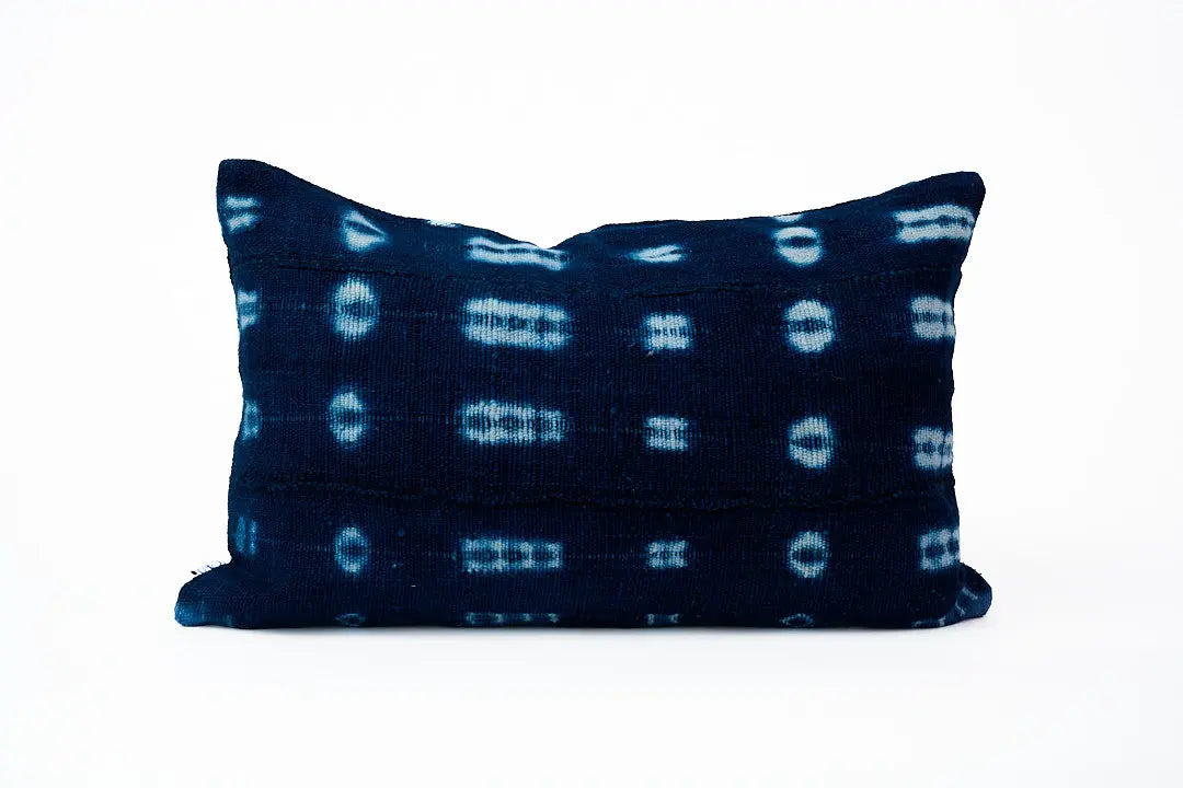 Housse de coussin ethnique en bogolan indigo BAHARINI. Entièrement réalisée à la main. Housse de coussin zippée rectangle 30 x 50 cm. 100% coton bio. Tissage et teinture artisanaux réalisés au Mali. Confection réalisée en Belgique. 