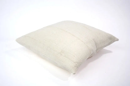 Housse de coussin crème en bogolan de coton bio par Studio Matongé. Pièces uniques tissées, filées et confectionnées à la main. Format carré 50 x 50 cm. 