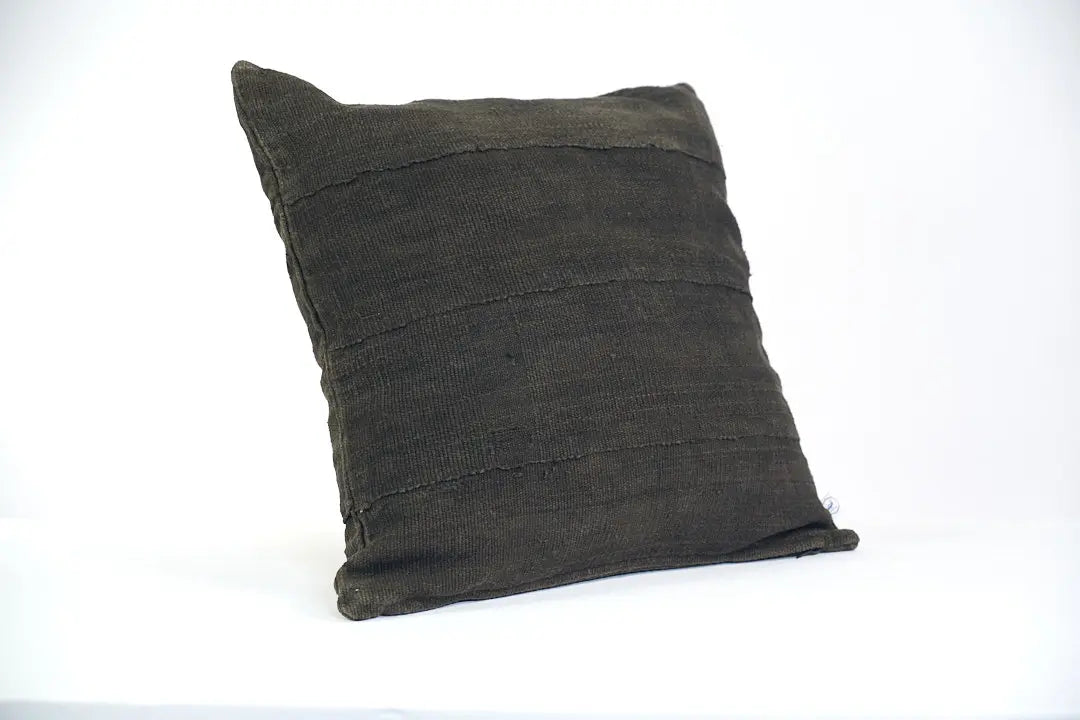 Housse de coussin noire en bogolan de coton bio par Studio Matongé. Pièces uniques tissées, filées et confectionnées à la main. Format carré 50 x 50 cm. 